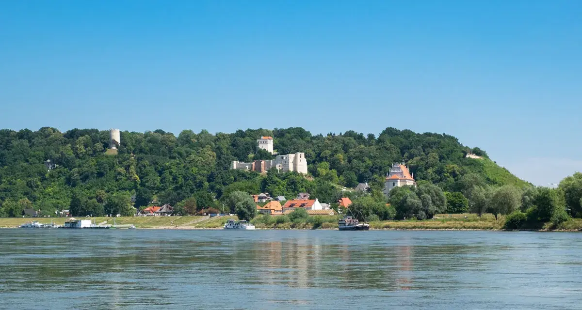 Widok na Wisłę i wzgórza z ruinami zamku oraz zabudowaniami. Kazimierz Dolny i okolice atrakcje zachwycają.