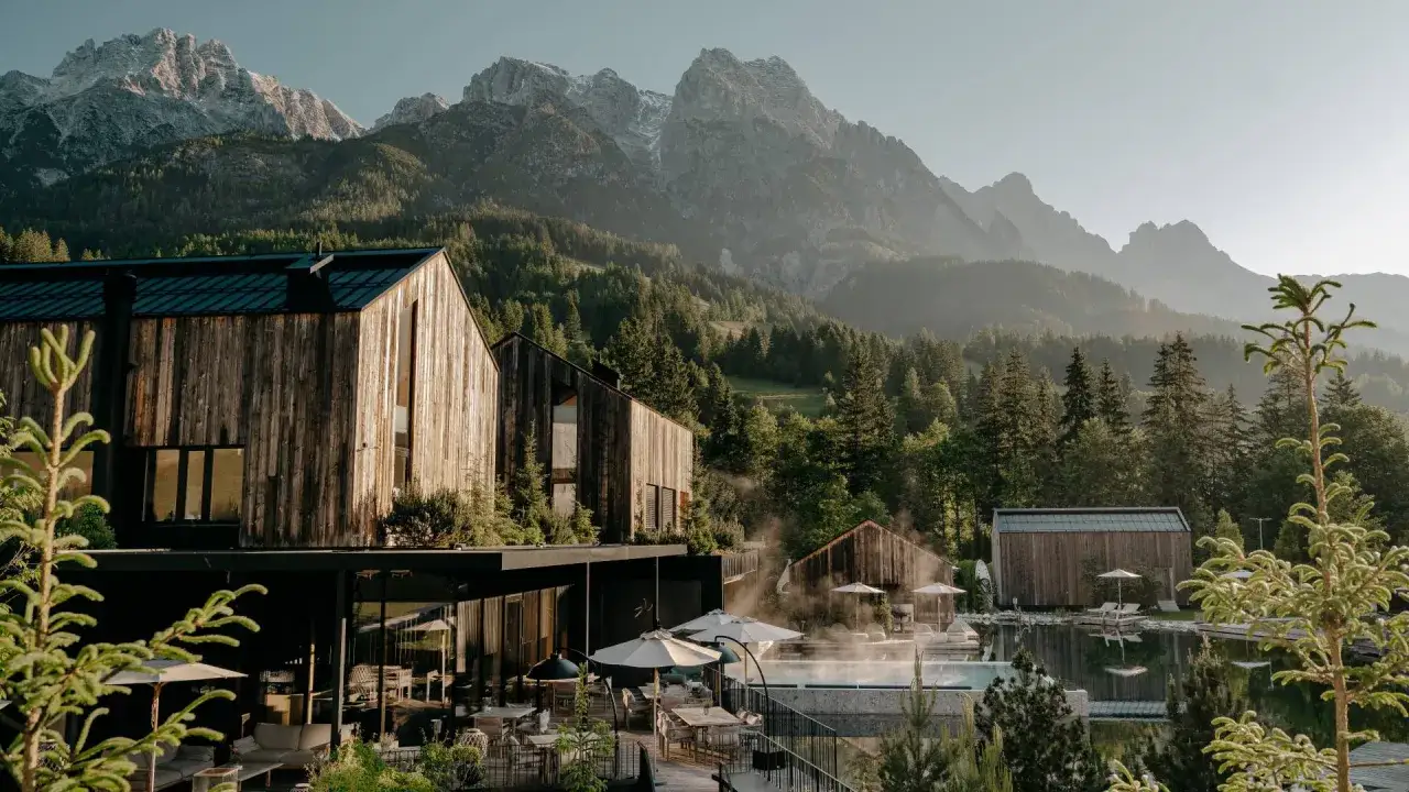 Nowoczesny hotel w lesie, z basenem i widokiem na góry. Drewniana architektura idealnie komponuje się z naturą.